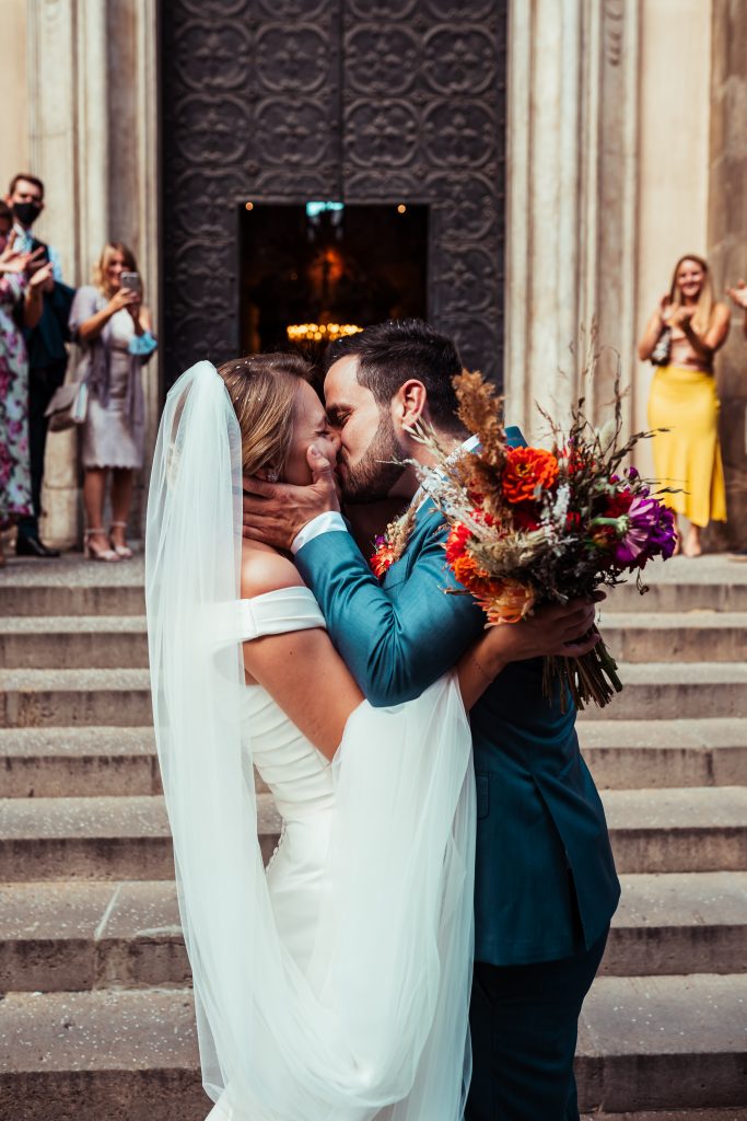 Para Młoda przed kościołem całuje się